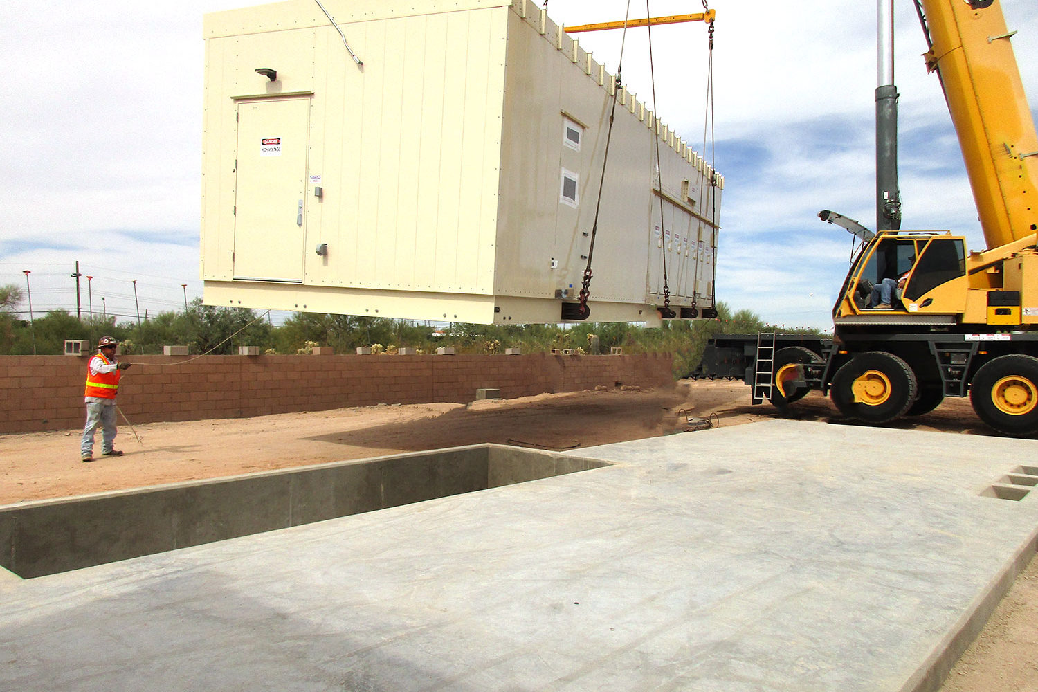 Enclosure being dropped into place by crane.