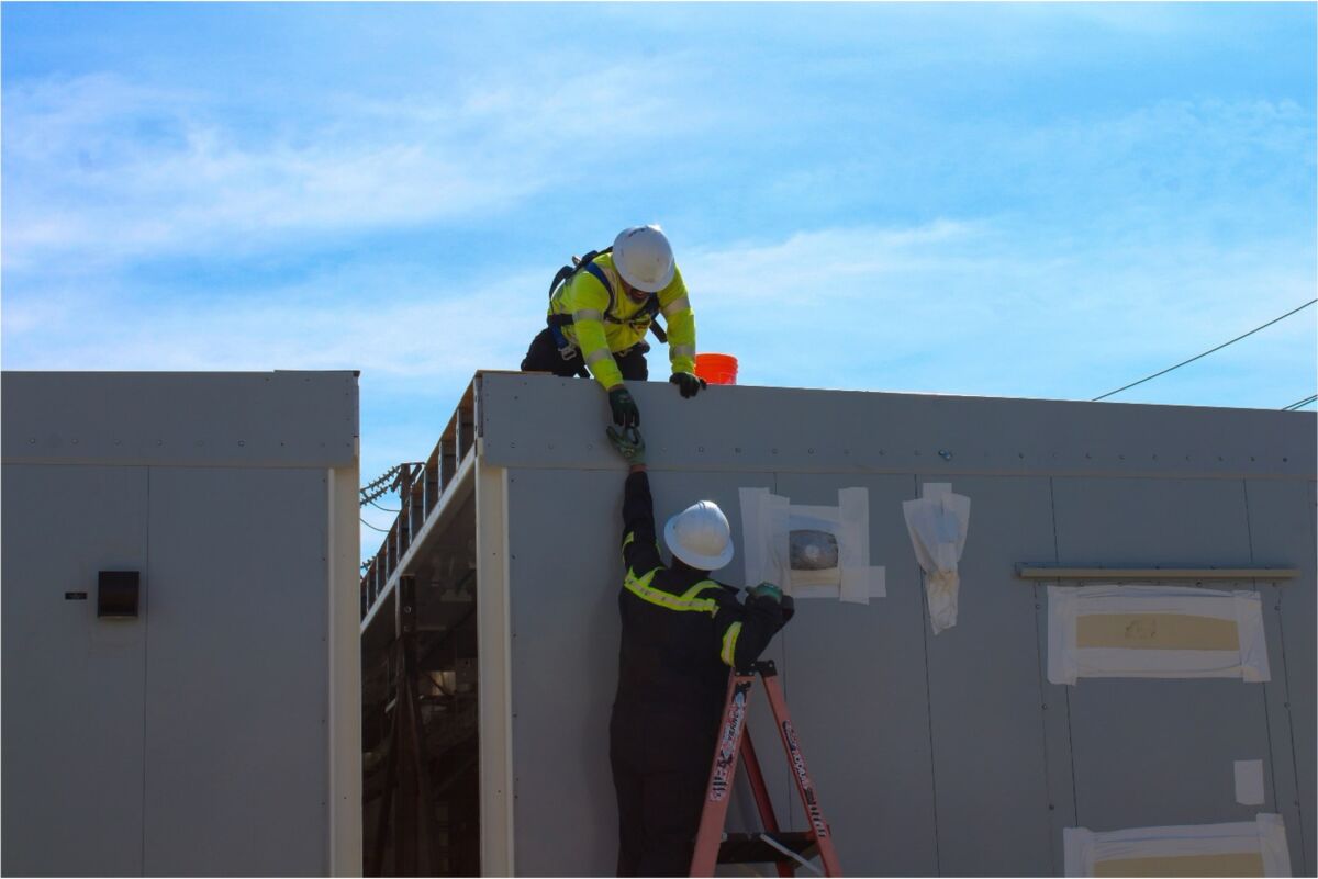 Crown Technical Systems team working on exterior of split building prior to assembly